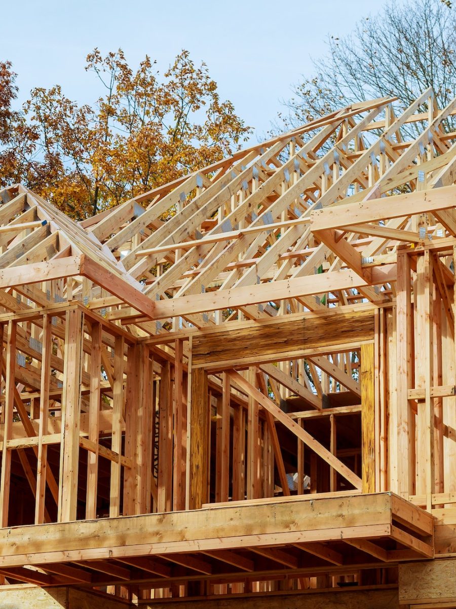 A stick built house under construction New build roof with wooden truss, post and beam framework.